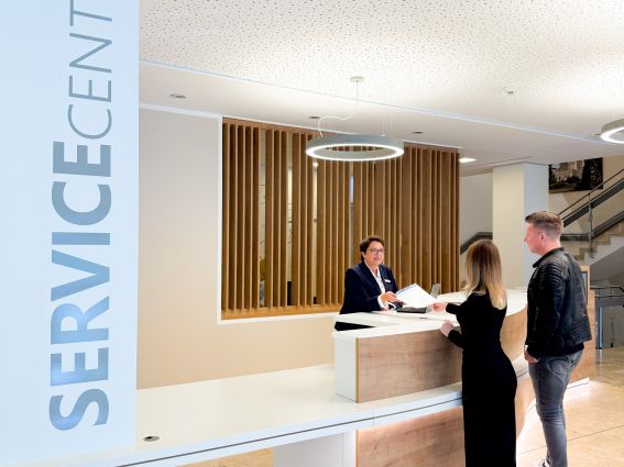 Tanja Berg (hinter dem Counter), Mitarbeiterin des ServiceCenters der Kreisverwaltung, ist mit ihren Kolleginnen und Kollegen im Einsatz und berät die Kundinnen und Kunden der Kreisverwaltung. © Kreis Paderborn